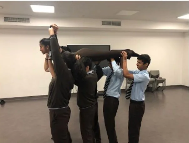 Drama students lift a classmate above their shoulders in the studio
