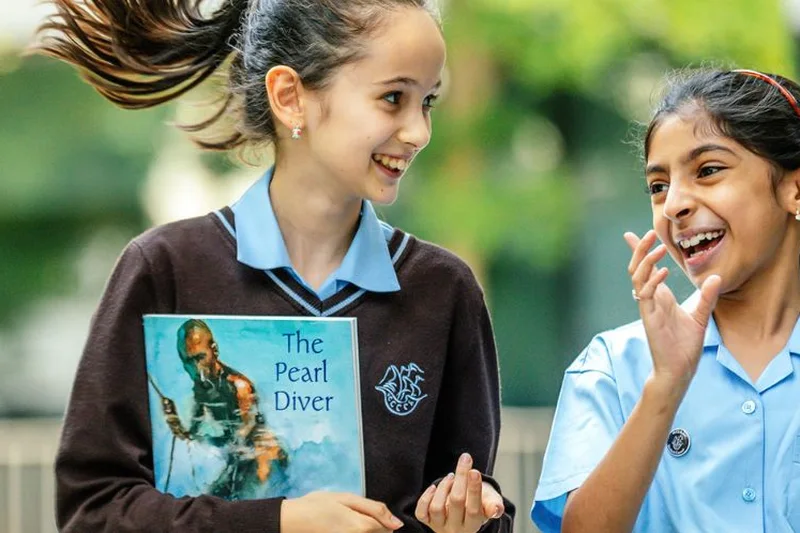 A Junior School girl holds up her copy of The Pearl Diver